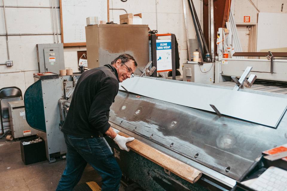 A Seattle Metals worker feeds a long sheet into the folder